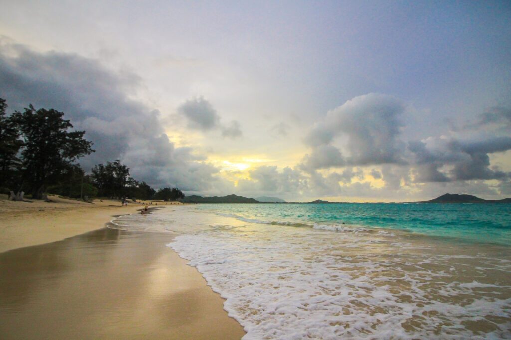 Hawaii blue ocean beach during sunset and clouds.